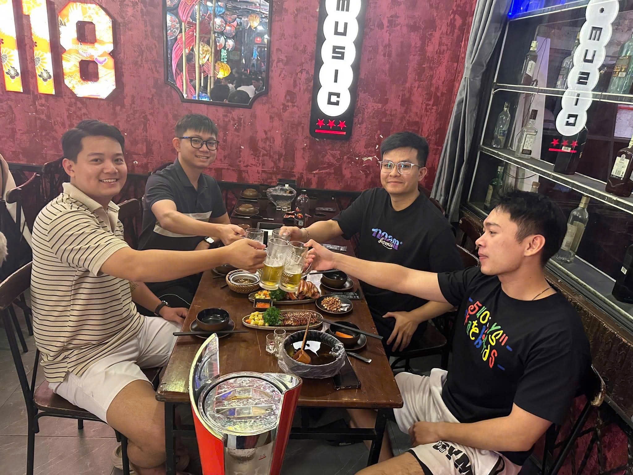 Nhóm bạn nâng ly bên bàn ăn